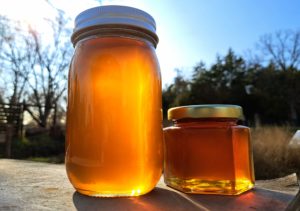 local honey hive honey jars glowing in the sunlight on a beautiful day